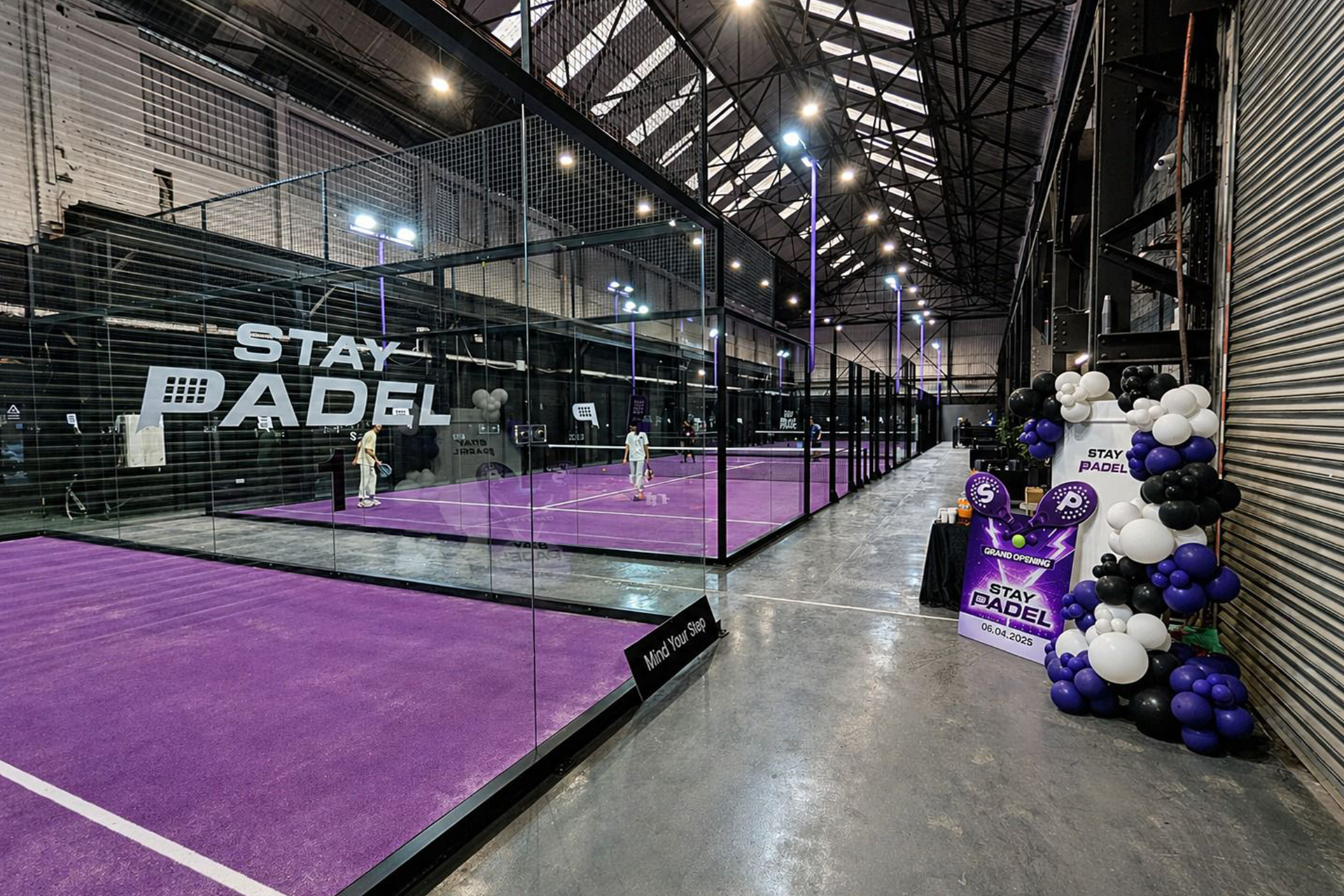 Row of indoor padel courts with glass panels at a facility in Manchester